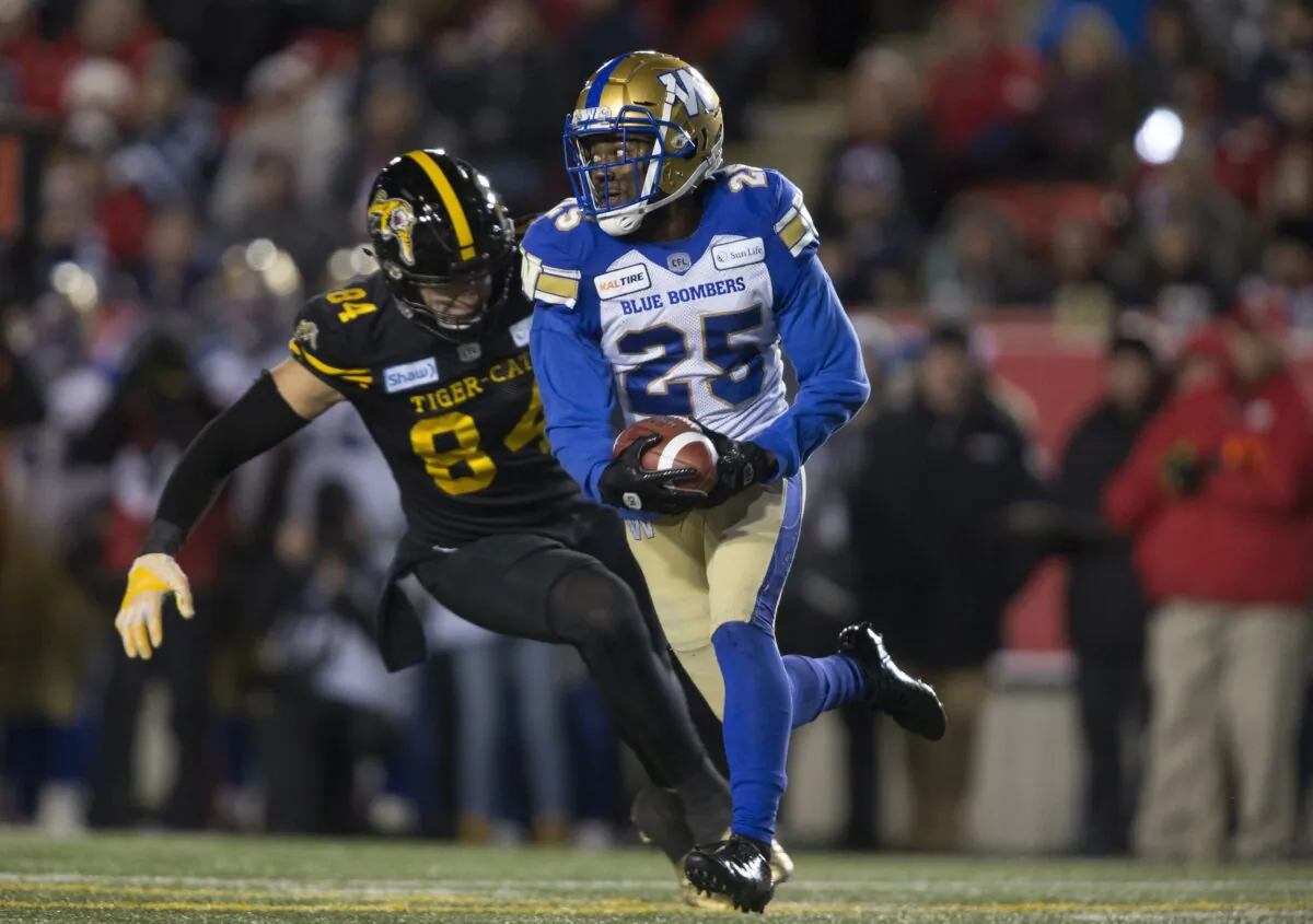 Hamilton Tiger-Cats' Nikola Kalinic chases Winnipeg Blue Bombers' Nick Taylor during the 107th Grey Cup in Calgary on Nov. 24, 2019. The 108th Grey Cup will be held in Hamilton on Dec. 12, 2021. (The Canadian Press/Jeff McIntosh)