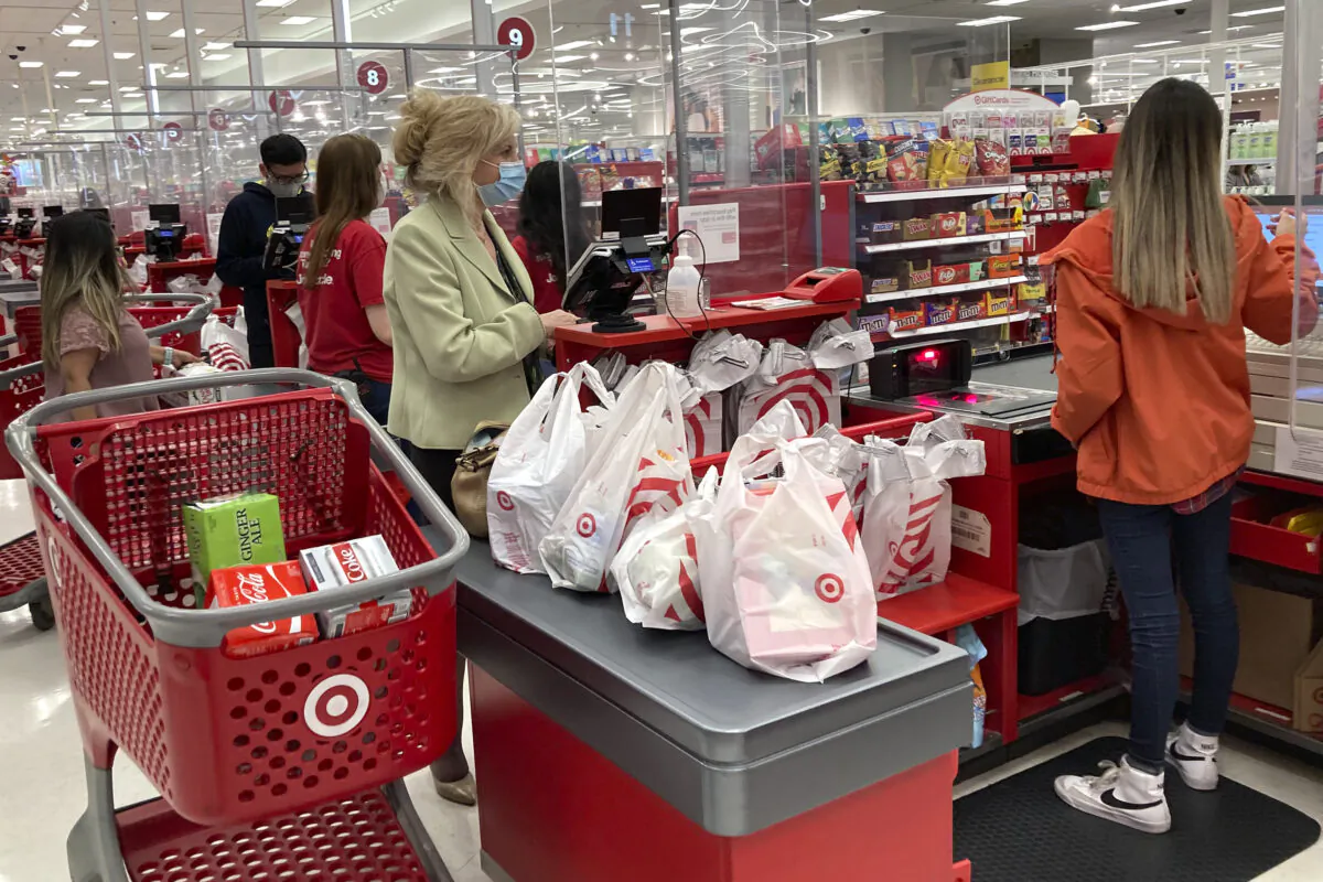 A customer wears a mask as she waits to get a receipt at a register in a Target store in Vernon Hills, Ill., Sunday, May 23, 2021. (AP Photo/Nam Y. Huh)