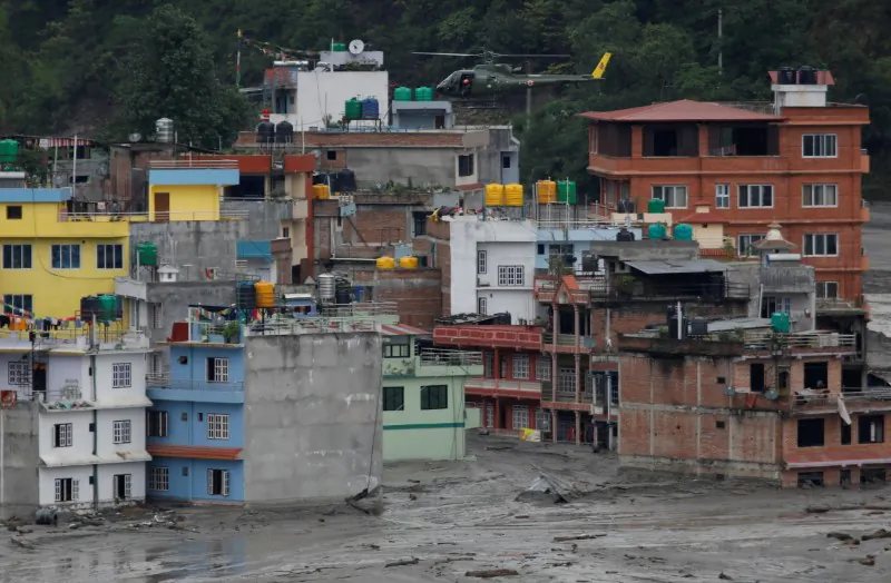 A Nepali army helicopter hovers above houses during a rescue mission in Sindhupalchok, Nepal, on June 16, 2021. (Navesh Chitrakar/Reuters)