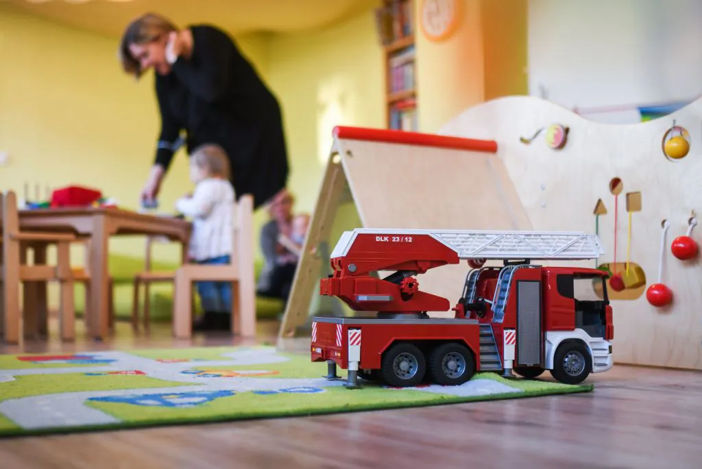 A nursery school teacher plays with children in a day care center in Recklinghausen, western Germany on Feb. 24, 2021. (Ina Fassbender/AFP via Getty Images)