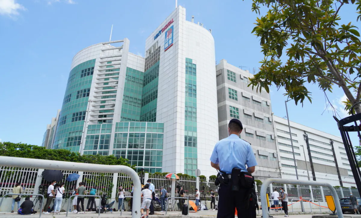 A Hong Kong police officer stands outside of the Apple Daily headquarters in Hong Kong on June 17, 2021. (Adrian Yu/The Epoch Times)