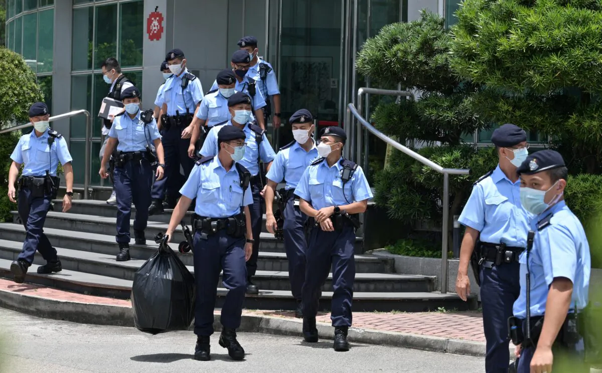 Police officers leave the Apple Daily newspaper offices in Hong Kong after a raid by over 500 officers on June 17, 2021. (Anthony Wallace/AFP via Getty Images)