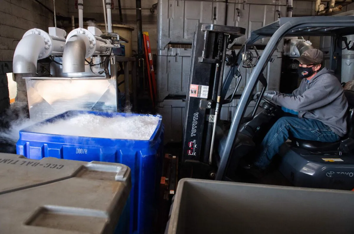 An employee at Capitol Carbonic, which makes dry ice used by the pharmaceutical industry, uses a forklift to move a cooler of dry ice pellets in a warehouse in Baltimore, Maryland, on Nov. 20, 2020. (Saul Loeb/AFP/Getty Images)