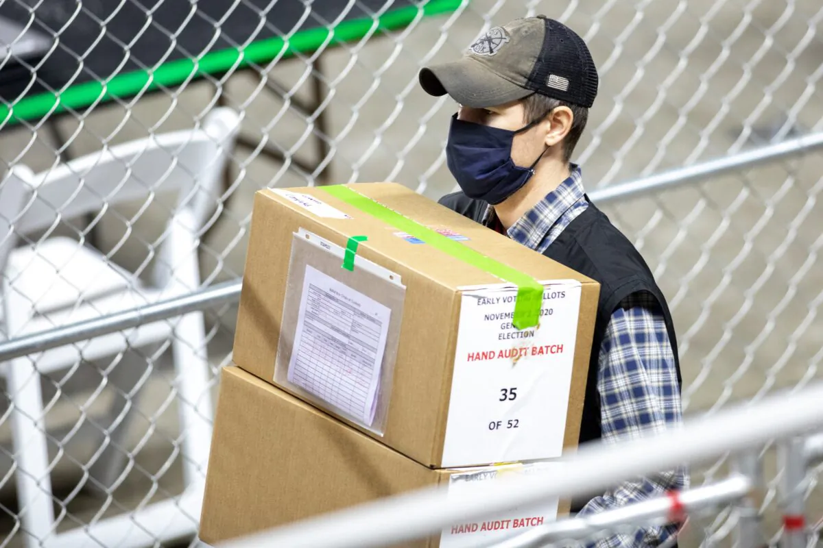 A contractor working for Cyber Ninjas, who was hired by the Arizona Senate, moves ballots during an audit of the 2020 election, at at Veterans Memorial Coliseum in Phoenix, Ariz., on May 1, 2021. (Courtney Pedroza/Getty Images)