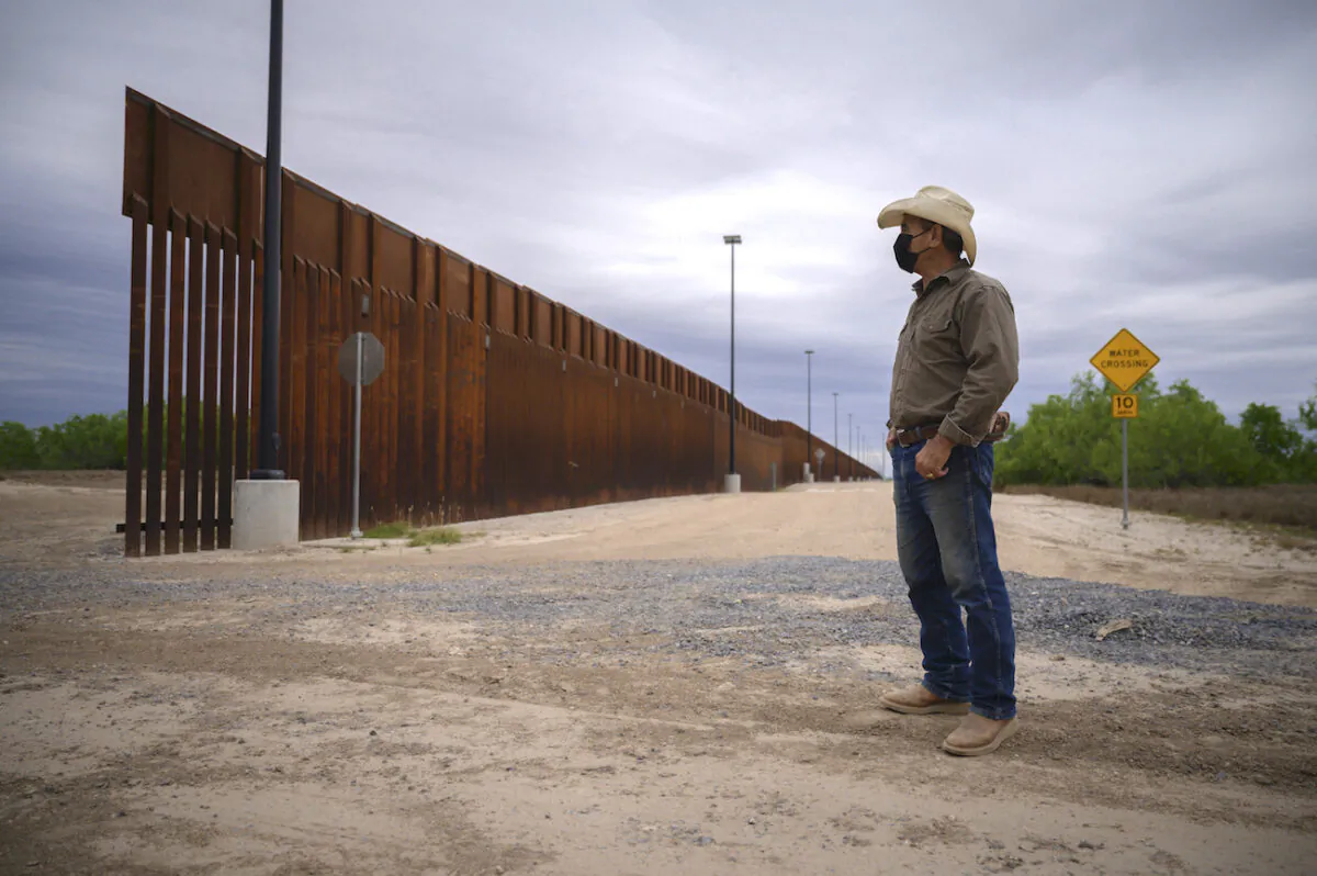A ranch owner stands before a portion of the unfinished border wall that former U.S. President Donald Trump tried to build, near Roma, Texas, on March 28, 2021. (Ed Jones/AFP via Getty Images)