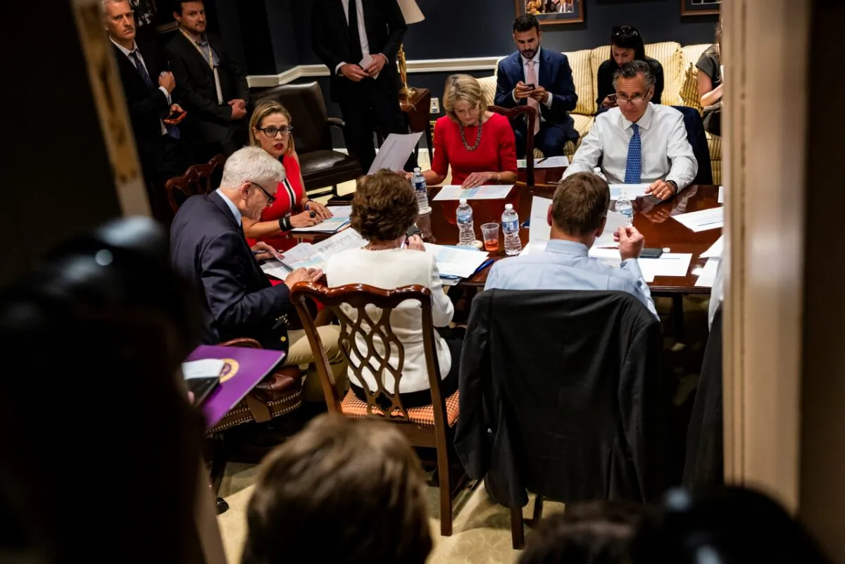(L-R) U.S. Sen. Bill Cassidy (R-LA), U.S. Sen. Kyrsten Sinema (D-AZ), U.S. Sen. Lisa Murkowski (R-AK), and U.S. Sen. Mitt Romney (R-UT) hold a bipartisan meeting on infrastructure in the basement of the U.S. Capitol building after original talks fell through with the White House in Washington on June 8, 2021. (Samuel Corum/Getty Images)
