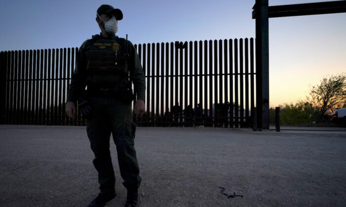 A U.S. border agent near a gate on the U.S.–Mexico border wall, in Abram-Perezville, Texas, in this file photo. (Julio Cortez/AP Photo)