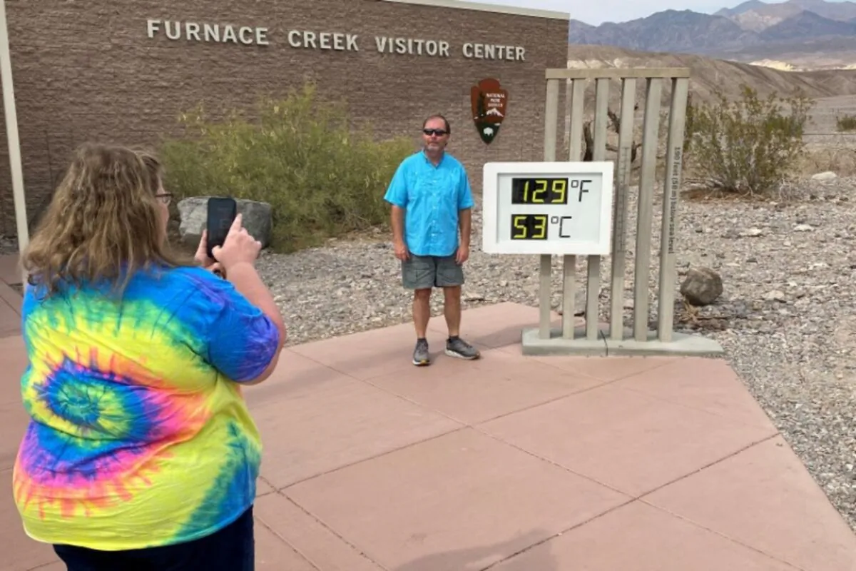 Patrick Fox, 63, from Utah poses for a picture next to the thermometer at the Furnace Creek Visitor Center at Death Valley National Park, with the temperature showing at 129 degrees Fahrenheit (53.8 degrees C) in Death Valley, Calif., on June 16, 2021. (Norma Galeana/Reuters)