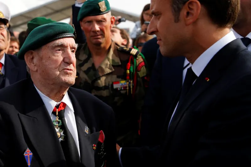 French President Emmanuel Macron listens to French war veteran Leon Gautier, a member of the Kieffer commando, during a D-Day commemoration ceremony in memory of marines and the famed Kieffer commandos who took part in D-Day landings, in Colleville-Montgomery, France, on June 6, 2019. (Francois Mori/Pool via Reuters)