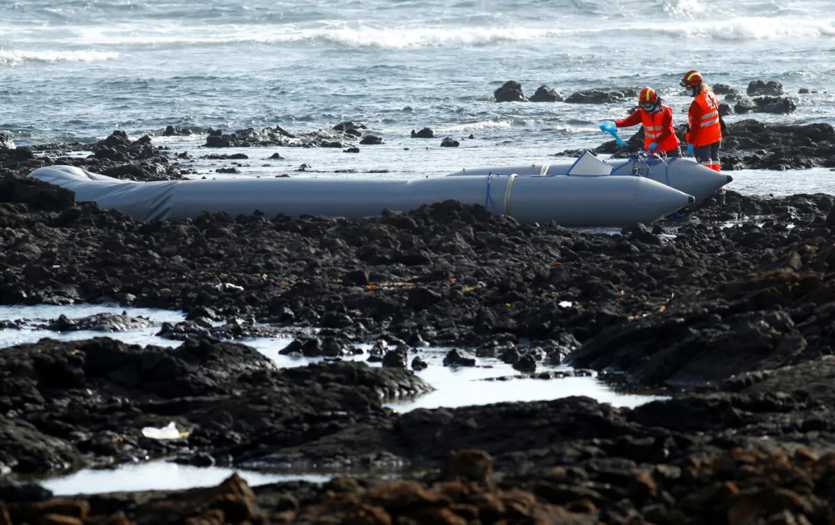 Rescue workers search for bodies after a boat with 46 migrants from the Maghreb region capsized in the beach of Orzola, in the Canary Island of Lanzarote, Spain, on June 18, 2021. (Borja Suarez/Reuters)