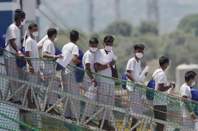 Migrants disembark the ship 'Geo Barents' run by Doctors Without Borders (MSF), which was given permission to dock at the Sicilian port of Augusta after a week of waiting at sea, to board the quarantine ship 'Aurelia', in Augusta, Italy, on June 18, 2021. (Antonio Parrinello/Reuters)