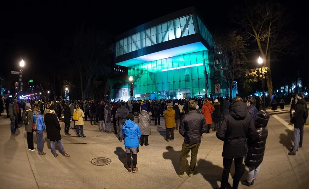 People gather at the Quebec National Museum in a vigil to honour Francois Duchesne who was stabbed to death on Halloween night by a man with a sword, on Nov. 3, 2020 in Quebec City. (The Canadian Press/Jacques Boissinot)