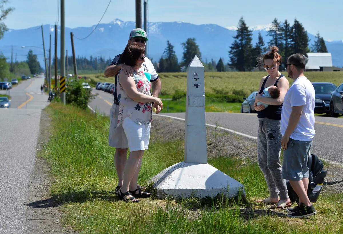 Daniel and Cheryl Sanchez, of Seattle, Washington, introduce their two week old baby to grandparents Rosemary and Roland Berezan of Surrey, during a roadside meet up along the Canada-U.S. border, closed to non-essential travel due to the coronavirus disease (COVID-19) restrictions as the family gathered for Mother's Day in Langley, British Columbia, Canada, on May 10, 2020.  (Jennifer Gauthier/Reuters)