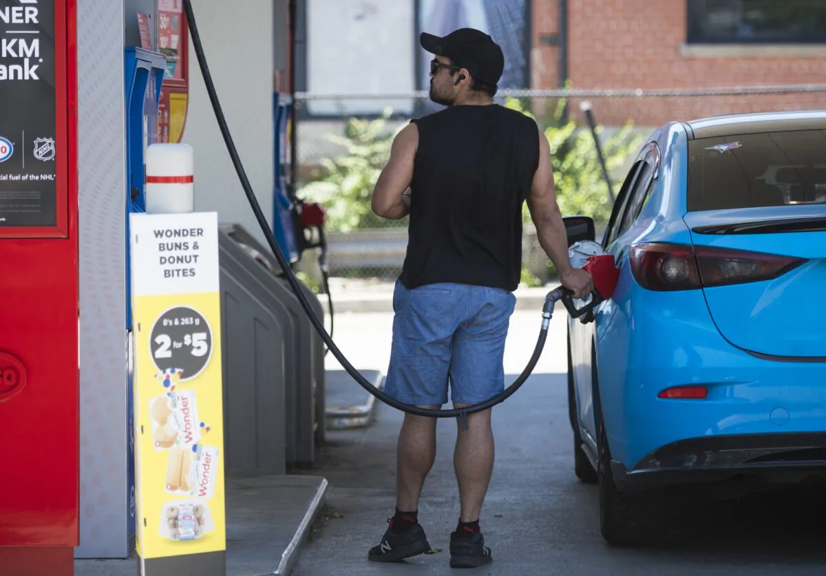 A commuter pumps gas into their vehicle at a Esso gas station in Toronto on June 15, 2021. (Tijana Martin/The Canadian Press)