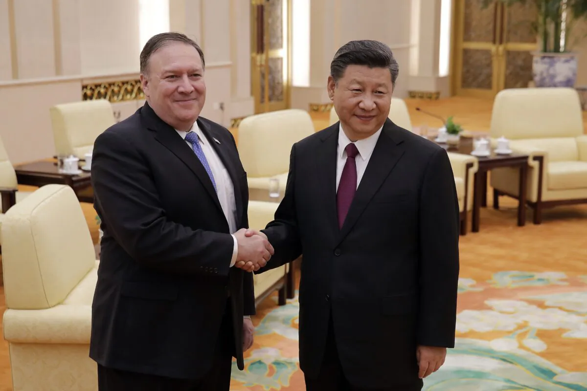 Then-Secretary of State Mike Pompeo (L) shakes hands with Chinese leader Xi Jinping as they pose for photograph at the Great Hall of the People in Beijing on June 14, 2018. (Andy Wong/AFP via Getty Images)
