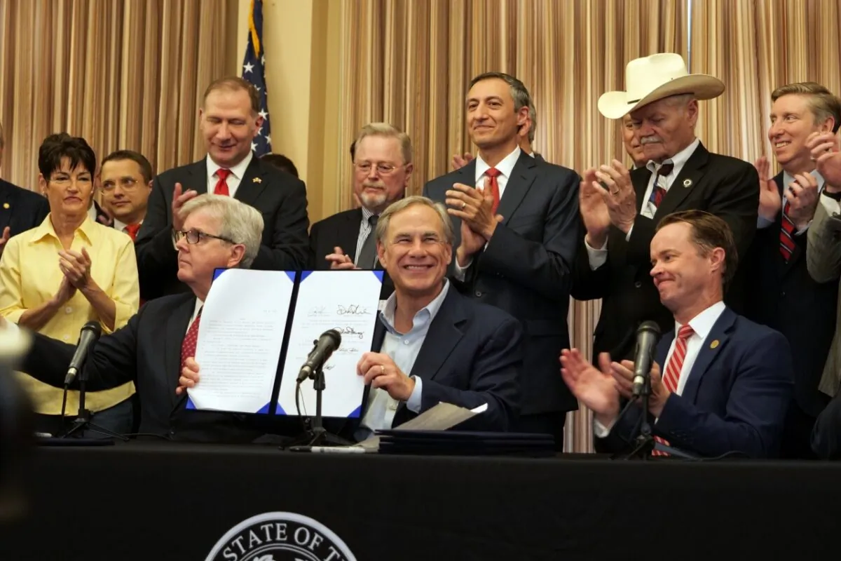 Texas Gov. Greg Abbott shows off a gun rights bill he signed, as (L) Lt. Gov. Dan Patrick, (R) Speaker Dade Phelan, members of state legislature, and representatives of the National Rifle Association look on during a press conference in San Antonio, Texas, on June 17, 2021. (Marina Fatina/NTD)