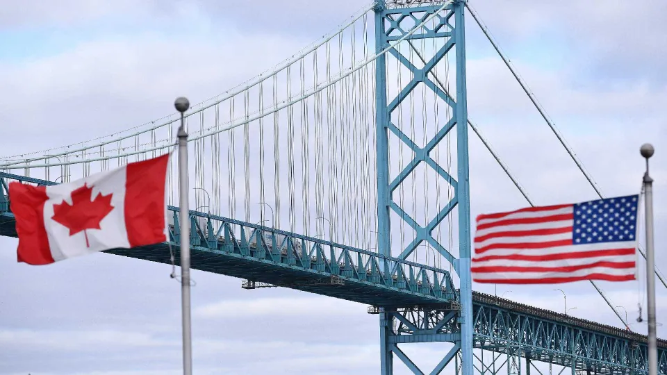 Canadian and American flags fly near the Ambassador Bridge at the Canada-USA border crossing in Windsor, Ont., on March 21, 2020. (The Canadian Press/Rob Gurdebeke)