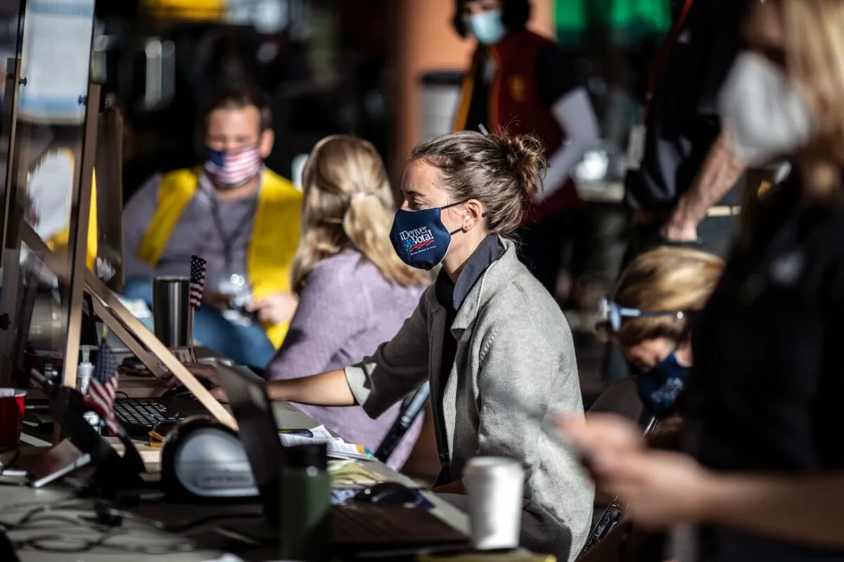 Poll workers check in voters at a polling location on election day in Denver, Colo., on Nov. 3, 2020. (Chet Strange/AFP via Getty Images)