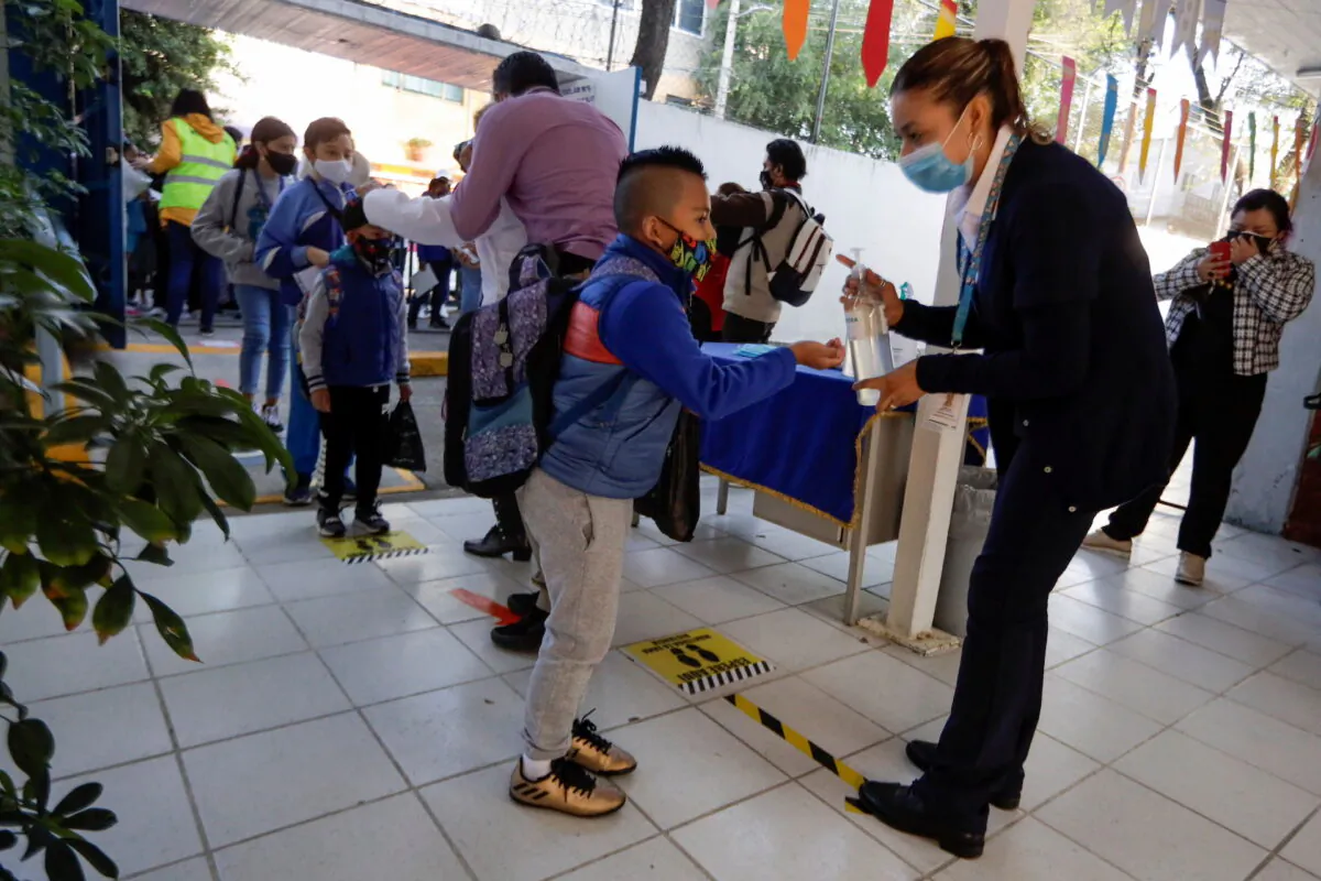 A child receives hand sanitizer while arriving at the Ignacio Zaragoza elementary school as Mexico City's authorities resumed in-person classes after a downward trend in the number of infections and hospitalizations of the coronavirus disease (COVID-19), in Mexico City, Mexico, June 7, 2021. (Luis Cortes/Reuters/File Photo)