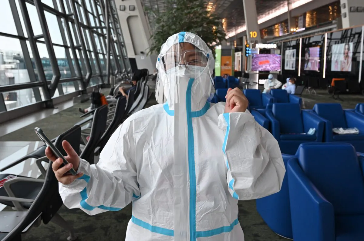 A Chinese passenger bound for Shenzhen, China, wears personal protective gear against COVID-19 before queuing to board a plane at the Sukarno Hatta international airport in Tangerang, Indonesia on June 8, 2021. (Adek Berry/AFP via Getty Images)