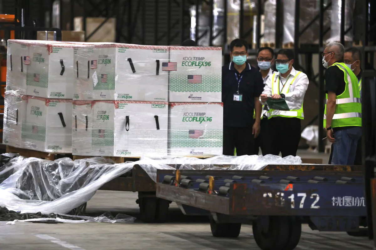 Workers transport Moderna vaccines shipped from the United States, to Taiwan Air Cargo Terminal at the Taoyuan International Airport in Taoyuan, Taiwan, on June 20, 2021. (Ann Wang/Reuters)