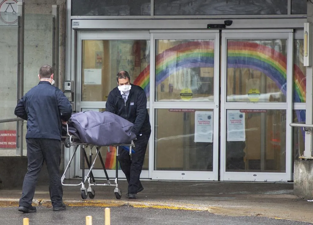 Funeral home workers remove a body from the Centre d'hebergement Sainte-Dorothee on April 13, 2020  in Laval Que.. The residence has reported over 100 confirmed cases of COVID-19. (The Canadian Press/Ryan Remiorz)