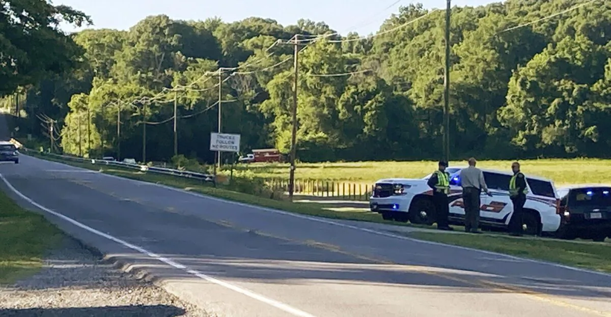 Rockingham County Sheriff Sam Page waits with other officials for the arrival of the State Highway Patrol's helicopter, equipped with infrared technology, to aid in the search for a group of missing rafters on June 17, 2021, in Eden, N.C. (Susan Spear/News & Record via AP)
