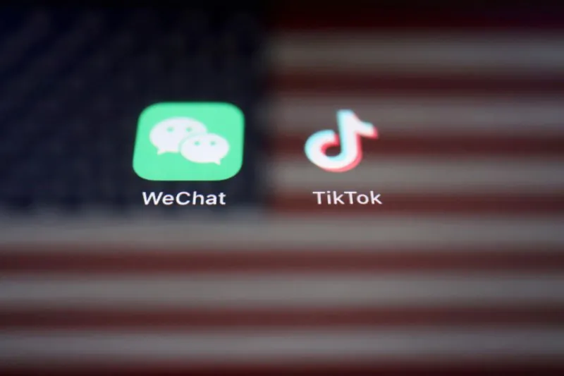 A reflection of the U.S. flag behind the WeChat and TikTok apps on Sept. 19, 2020. (Florence Lo/Reuters)