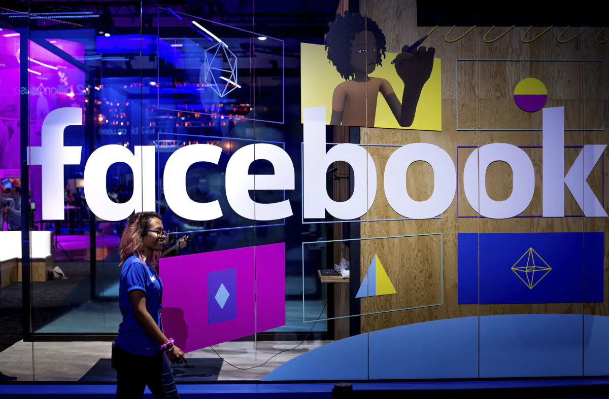 A conference worker passes a demo booth at Facebook's annual F8 developer conference, in San Jose, Calif., on April 18, 2017. (Noah Berger/AP Photo)