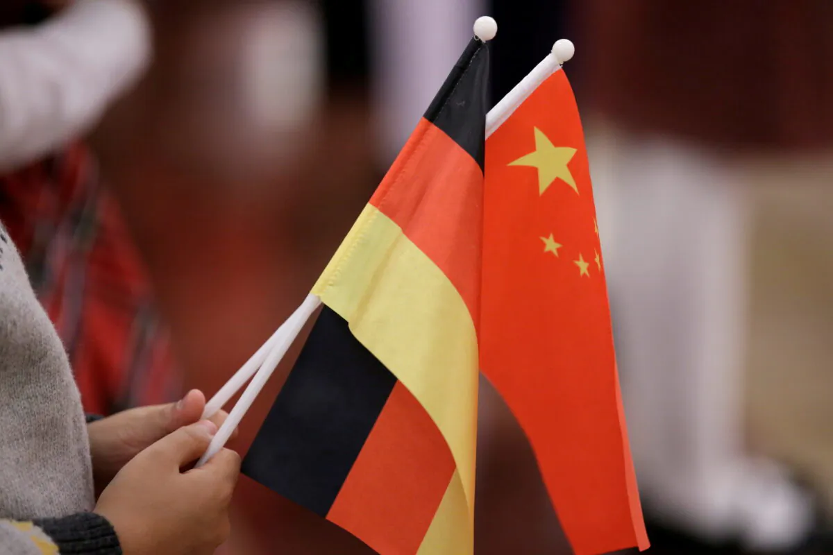 A student holds flags of China and Germany before a welcome ceremony hosted by China's President Xi Jinping for German President Frank-Walter Steinmeier at the Great Hall of the People in Beijing, China. Dec. 10, 2018. (REUTERS/Jason Lee)