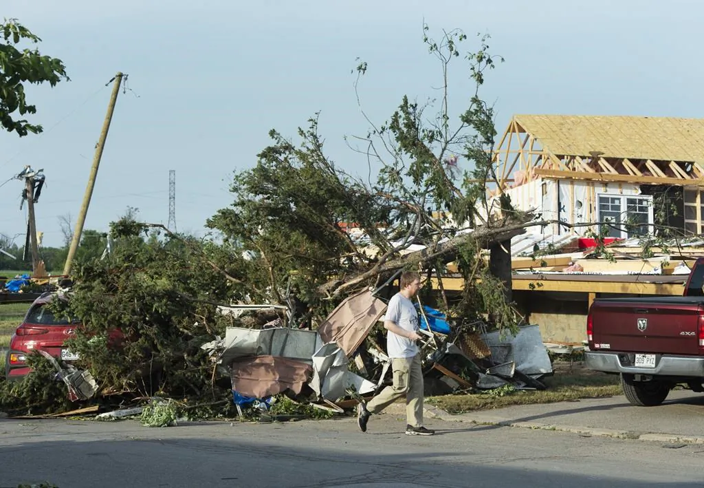A man surveys the damage after a tornado touched down in Mascouche, Que., northeast of Montreal, on June 21, 2021. Dozens of homes were damaged and one death has been confirmed. (The Canadian Press/Ryan Remiorz)