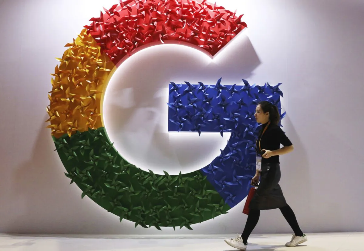 A woman walks past the logo for Google at the China International Import Expo in Shanghai, on Nov. 5, 2018. (Ng Han Guan/AP Photo)