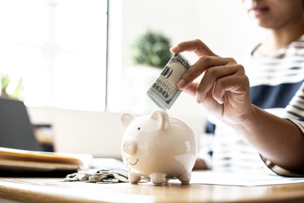 A,Business,Woman,Is,Putting,Dollar,Bills,In,A,White