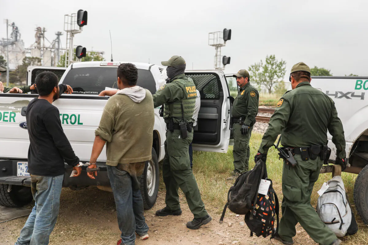 Border Patrol agents apprehend illegal aliens from Mexico who had hidden in a grain hopper on a freight train heading to San Antonio, near Uvalde, Texas, on June 21, 2021. (Charlotte Cuthbertson/The Epoch Times)