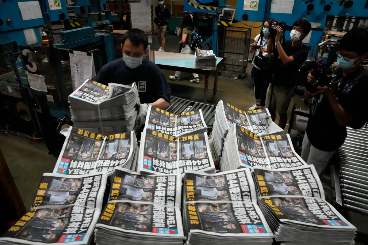 A worker packs copies of the Apple Daily newspaper at the printing house in Hong Kong on June 18, 2021. (AP Photo/Kin Cheung)
