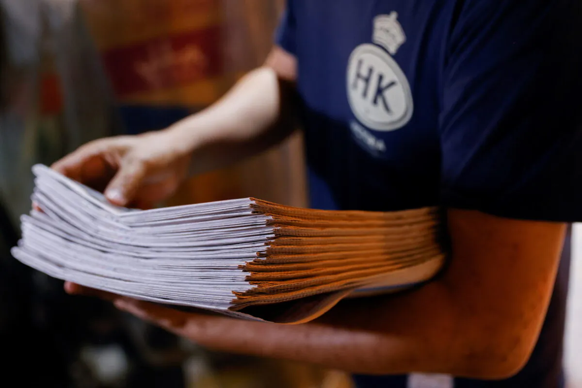 A supporter purchases copies of the Apple Daily newspaper from a newspaper stall after it looked set to close following police raids and the arrest of executives in Hong Kong, on June 22, 2021. (Tyrone Siu/Reuters)