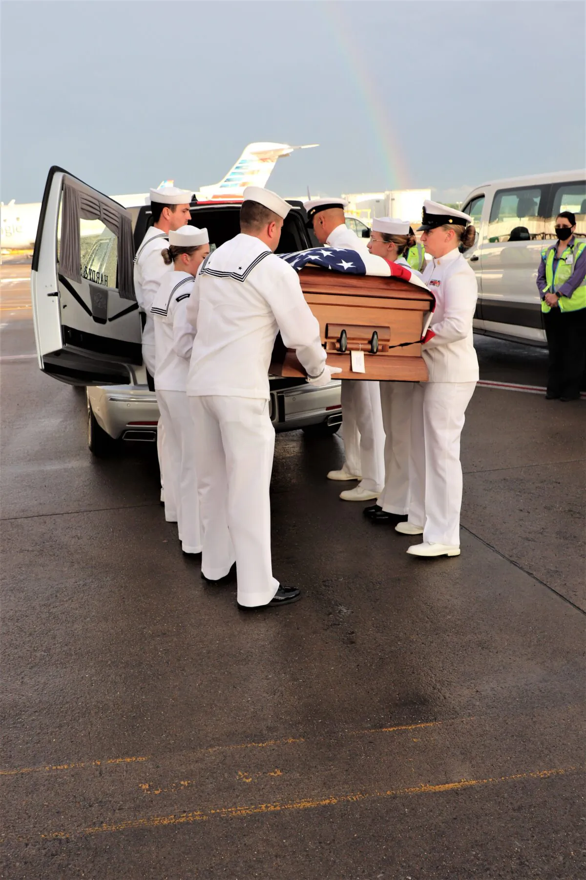 Navy Honor Guard from the Navy Operational Support Center in Louisville, Ky., place the remains of Scott Magers in a hearse as a rainbow glows overhead at Nashville, Tenn., International Airport on May 26, 2021 (James Perry)