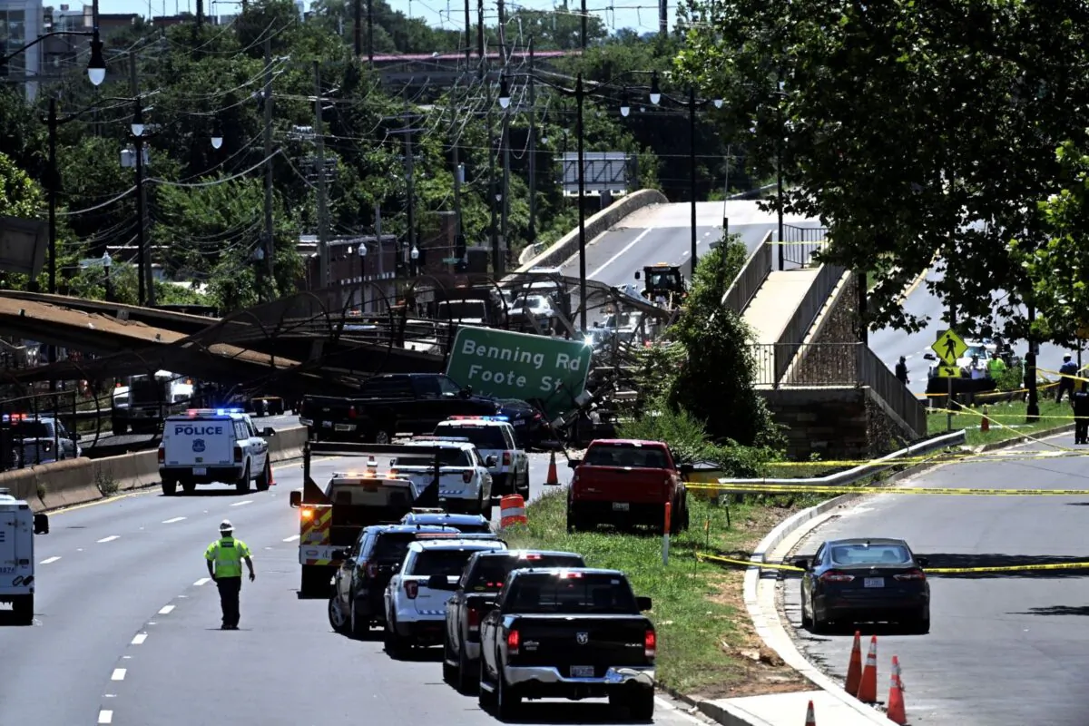 People work on the scene of a collapsed pedestrian bridge along Kenilworth Avenue & Polk Street Northeast in Washington, on June 23, 2021. (Marvin Joseph/The Washington Post via AP)