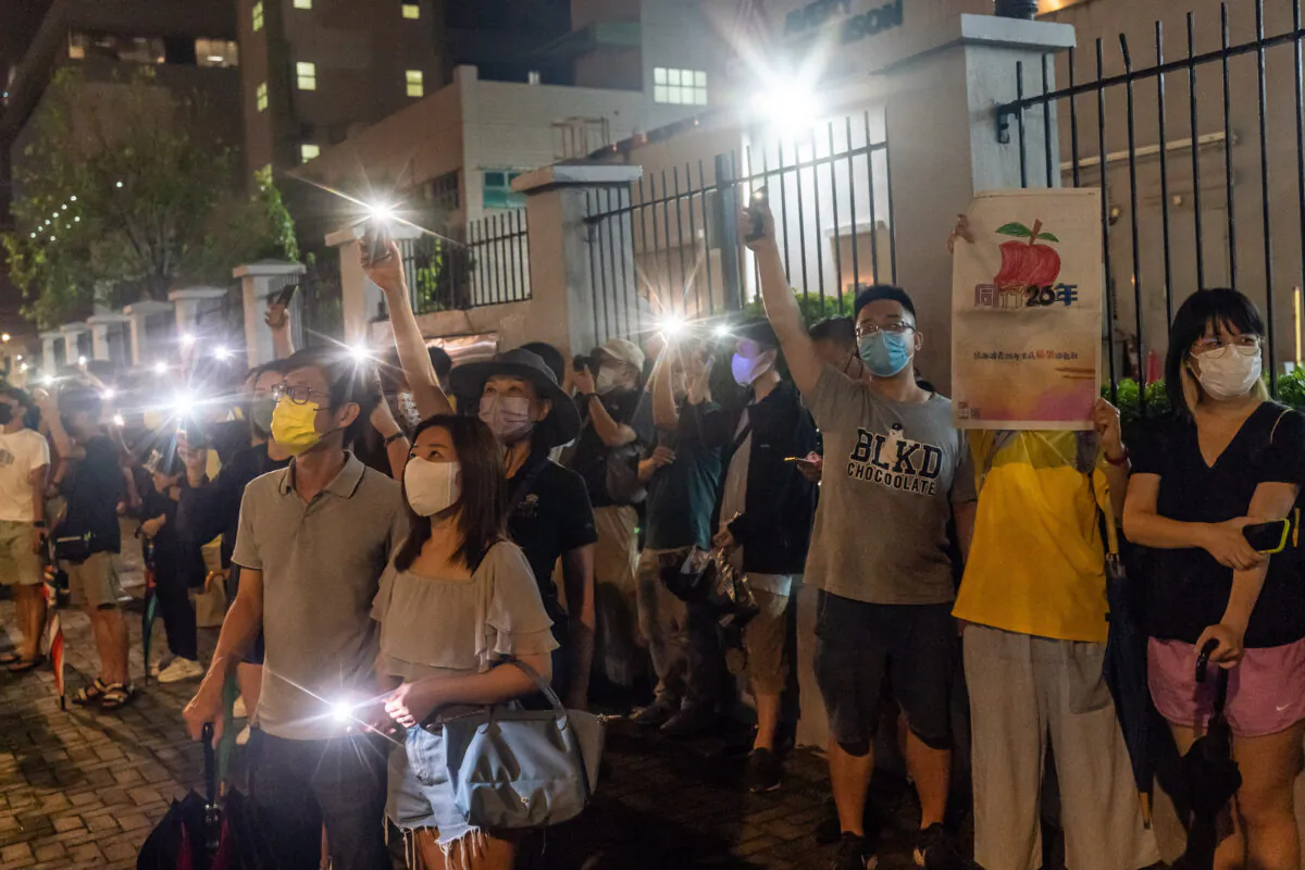 Supporters shine their smartphone lights towards the Apple Daily newspaper offices in Hong Kong, on June 23, 2021. (Anthony Kwan/Getty Images)