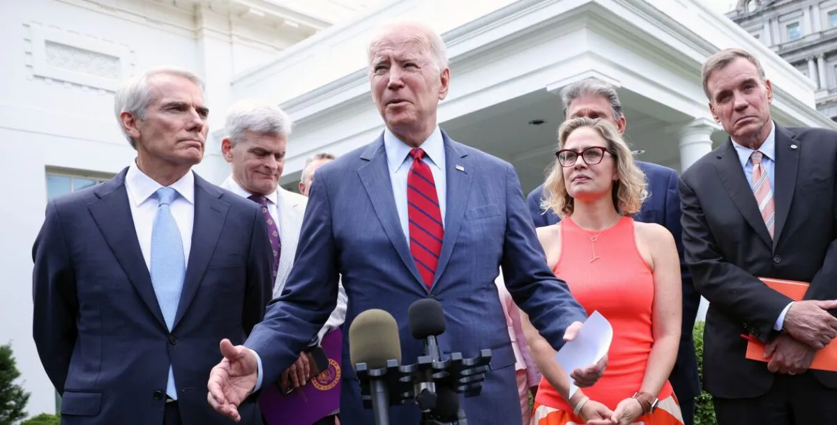 President Joe Biden (C), joined by from left to right, Sen Jeanne Shaheen (D-NH), Sen. Rob Portman (R-OH), Sen Bill Cassidy (R-LA), Sen. Kyrsten Sinema (D-AZ), Sen. Mark Warner (D-VA) and Sen Mitt Romney (R-UT), speaks after the bipartisan group of Senators reached a deal on an infrastructure package at the White House on June 24, 2021 (Kevin Dietsch/Getty Images)