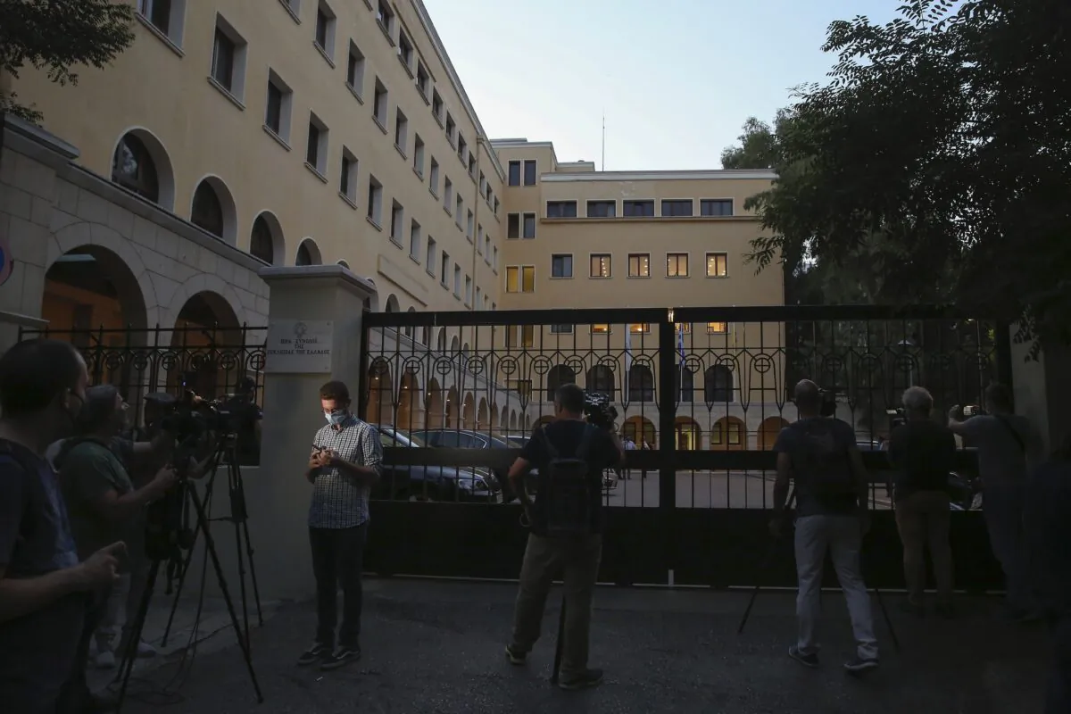 Journalists and cameramen stand outside Petraki Monastery in Athens, following an attack with a caustic liquid on June 23, 2021. (Petros Giannakouris/AP Photo)