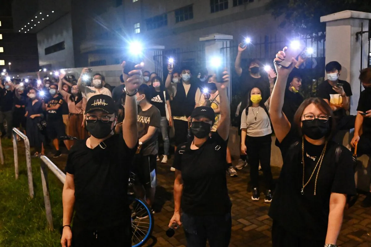 Supporters of Hong Kong newspaper Apple Daily wave their cellphone lights outside of the paper’s headquarters in Hong Kong on June 23, 2021. (Sung Pi-lung/The Epoch Times) 