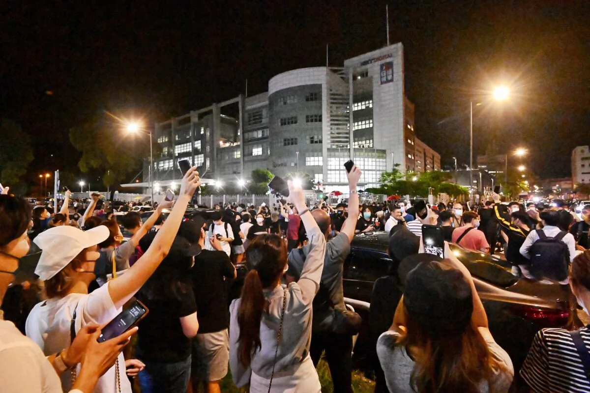 Supporters of Hong Kong newspaper Apple Daily wave their cellphone lights outside of the paper’s headquarters in Hong Kong on June 23, 2021. (Sung Pi-lung/The Epoch Times)