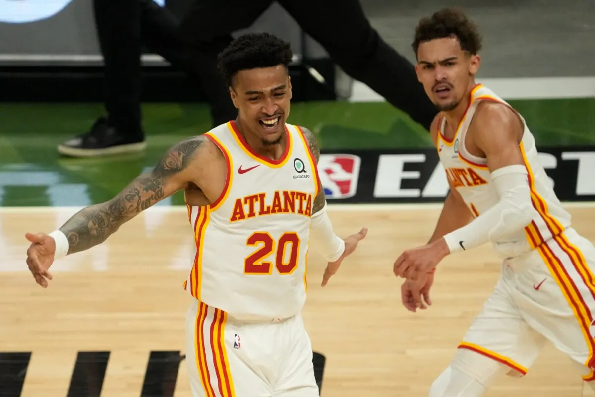 Atlanta Hawks' John Collins reacts after a dunk assisted by Trae Young during the second half of Game 1 of the NBA Eastern Conference basketball finals game against the Milwaukee Bucks, in Milwaukee, Wis., on June 23, 2021. (Morry Gash/AP Photo)