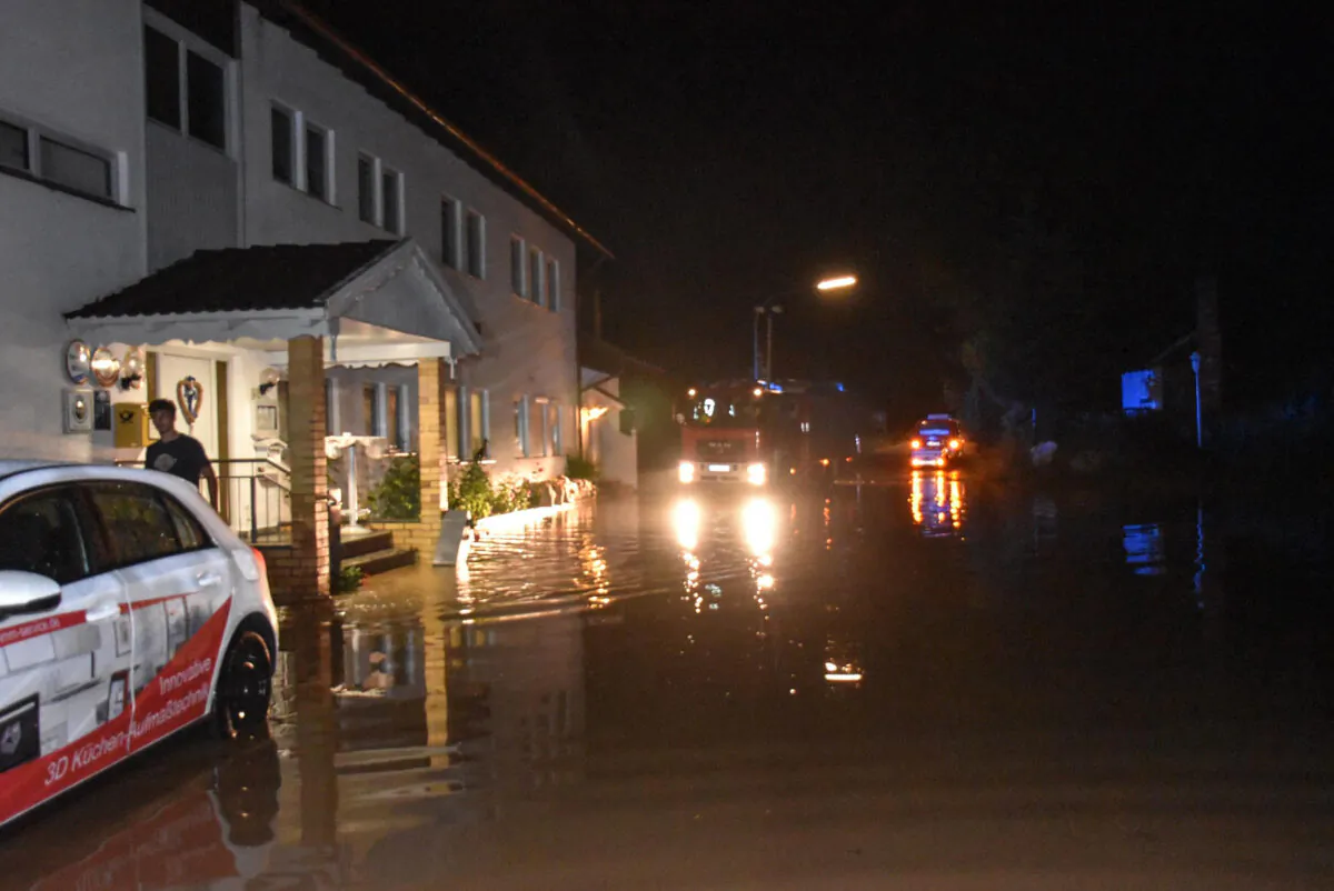 Cars park at a flooded road in Kopfsberg, Germany, on June 24, 2021. (Seidl/dpa via AP)