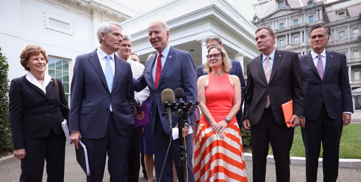 President Joe Biden (C), joined by from left to right, Sen. Jeanne Shaheen (D-NH), Sen. Rob Portman (R-OH), Sen. Bill Cassidy (R-LA), Sen. Kyrsten Sinema (D-AZ), Sen. Mark Warner (D-VA) and Sen. Mitt Romney (R-UT), speaks after the bipartisan group of Senators reached a deal on an infrastructure package at the White House on June 24, 2021 (Kevin Dietsch/Getty Images)