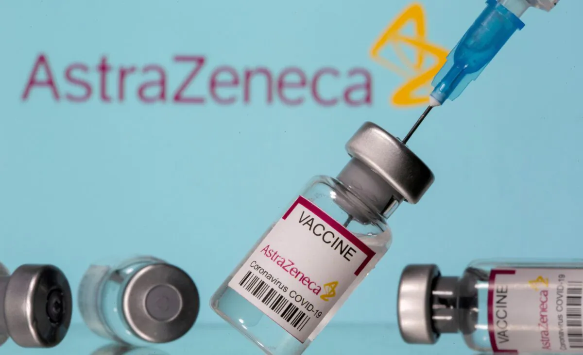 AstraZeneca COVID-19 Coronavirus Vaccine and a syringe are seen in front of a displayed AstraZeneca logo, in this illustration photo taken on March 14, 2021. (Dado Ruvic/Reuters)