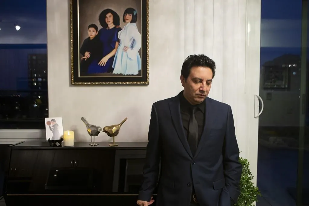 Alireza Ghandchi is photographed in front of a portrait of his wife Faezeh, daughter Dorsa and son Daniel in Richmond Hill , Ont., on January 1, 2021. Ghandchi lost his family after Iranian forces shot down a Ukrainian passenger jet on Jan. 8, 2020. (The Canadian Press/Chris Young) 