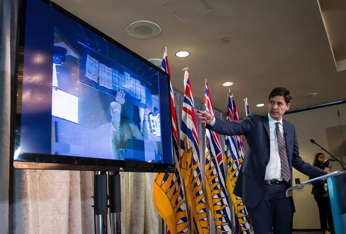 Bundles of cash brought to a casino by an individual are shown on a screen as B.C. Attorney General David Eby releases an independent review of anti-money laundering practices in the province’s gambling industry, at a news conference in Vancouver on June 27, 2018. (The Canadian Press/Darryl Dyck)