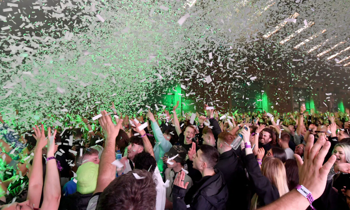 Confetti is fired into the crowd as Nightclub Circus hosts the first dance event, which will welcome 6,000 clubbers to the city's Bramley-Moore Dock warehouse in Liverpool, England, on April 30, 2021. (Anthony Devlin/Getty Images)